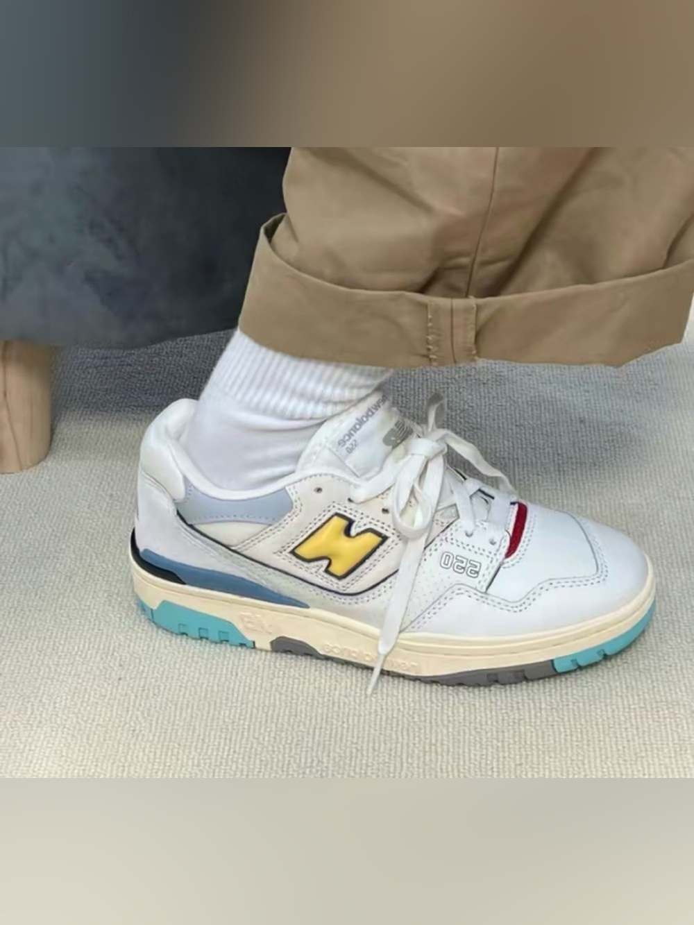 New Balance 550 White Sneakers with Yellow Logo and Blue Sole Accents